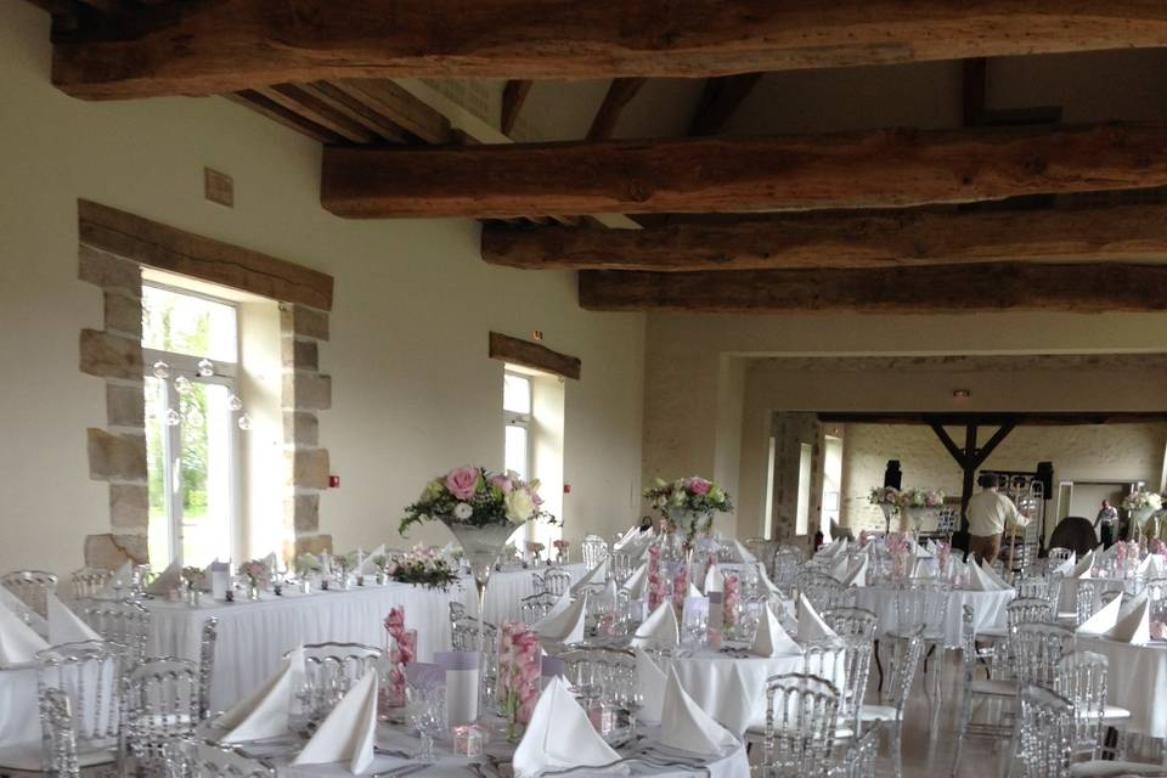Salle de réception aux poutres apparentes dressée pour un mariage en Seine-et-Marne